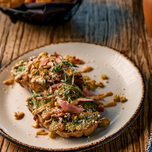 A plated dish with greens, herbs, and a light sauce on top; looks like a fresh, elegant entr&eacute;e or pasta garnish.