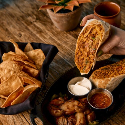 Crispy roasted chicken pieces and sizzling sausages on a hot grill with herbs and a dipping sauce on the side.